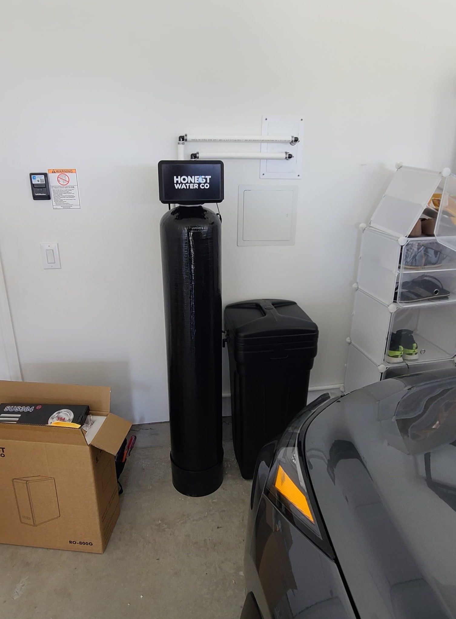 Honest Water Co whole-home system freshly installed in a North Texas garage: softener tank, brine tank, and plumbing tied into the main supply line